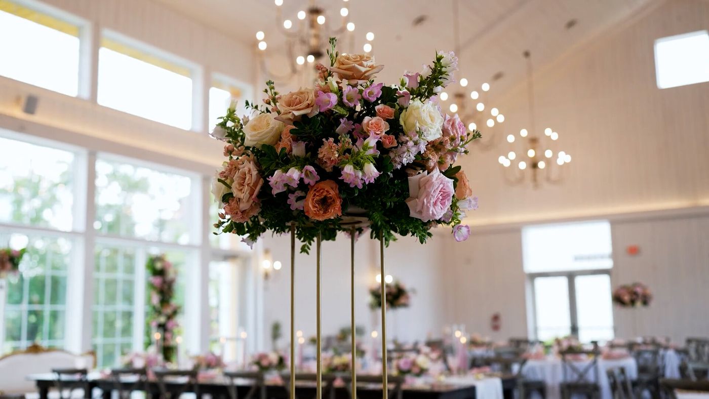 Tall floral centerpiece in a bright reception hall